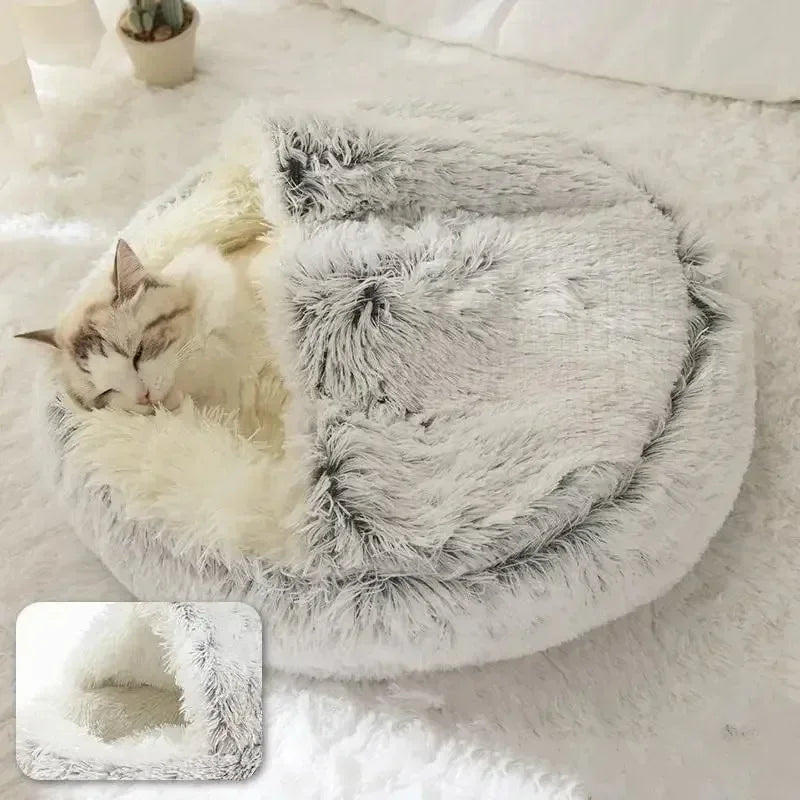 Fluffy pet bed with a cat inside on a soft surface
