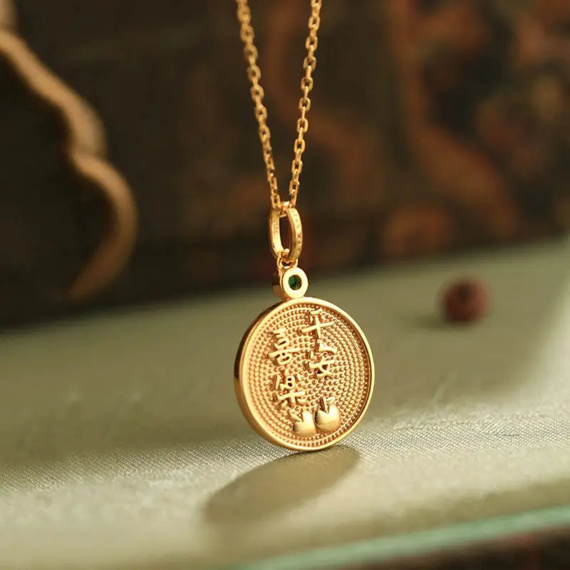 Gold necklace with a round pendant on a textured surface