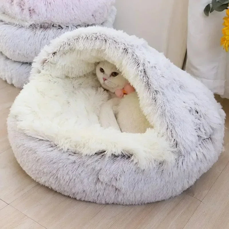 Cat inside a fluffy white pet bed on a light wooden floor.