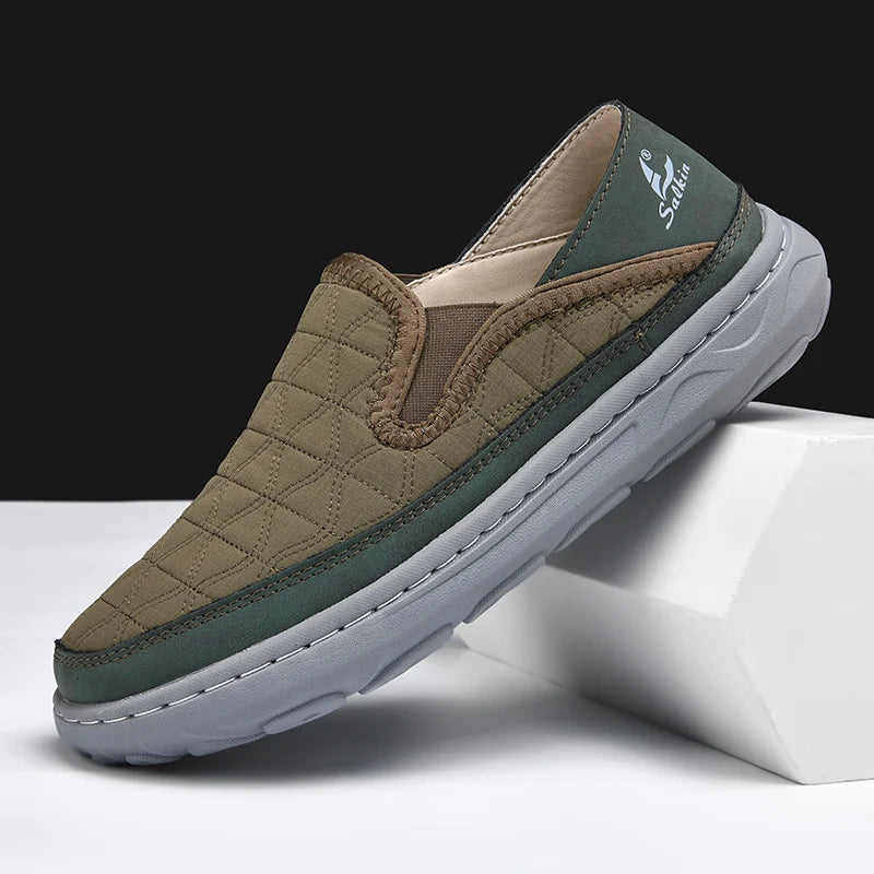 Green slip-on shoe with quilted design on a white surface