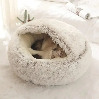 Cat lying in a fluffy white pet bed on a soft surface