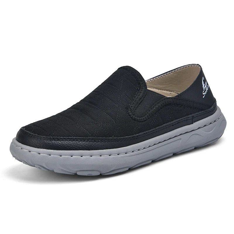 Black slip-on shoe with gray sole on a white background