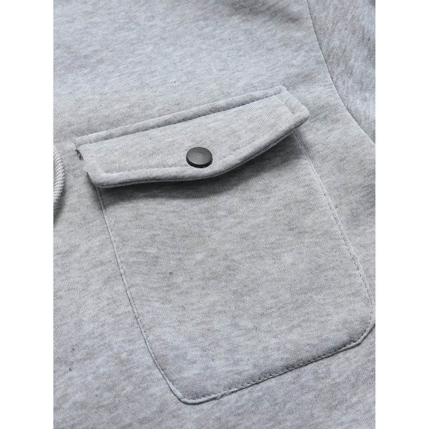 Close-up of a gray pocket on a garment with a button.