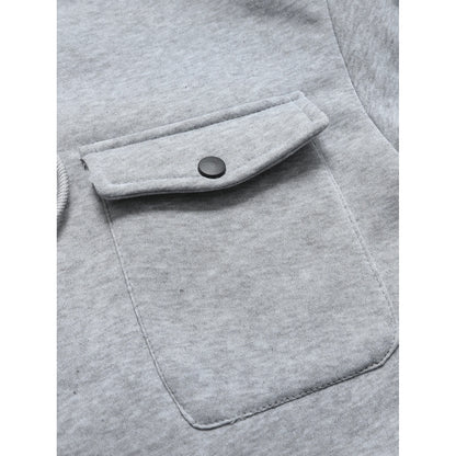 Close-up of a gray pocket on a garment with a button.