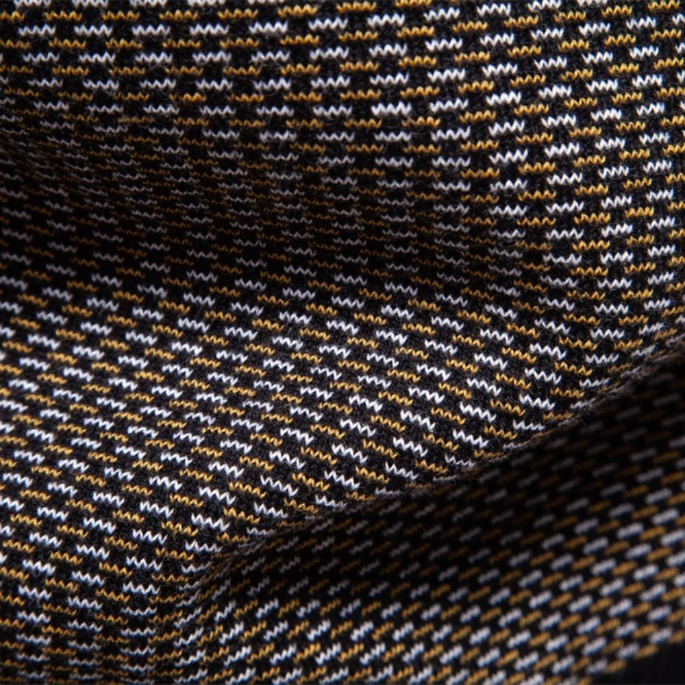 Close-up of a textured fabric with a pattern of black, white, and orange lines.