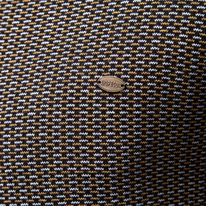 Close-up of a patterned fabric with a brand logo in the center.