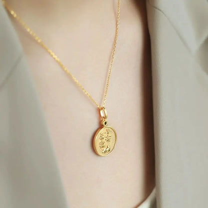 Gold necklace with a pendant on a neutral background