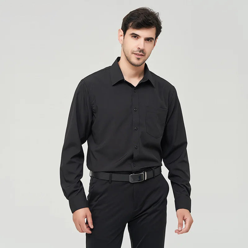 A front view of a man standing, wearing a black button up dress shirt, dark blue pants and a black belt.